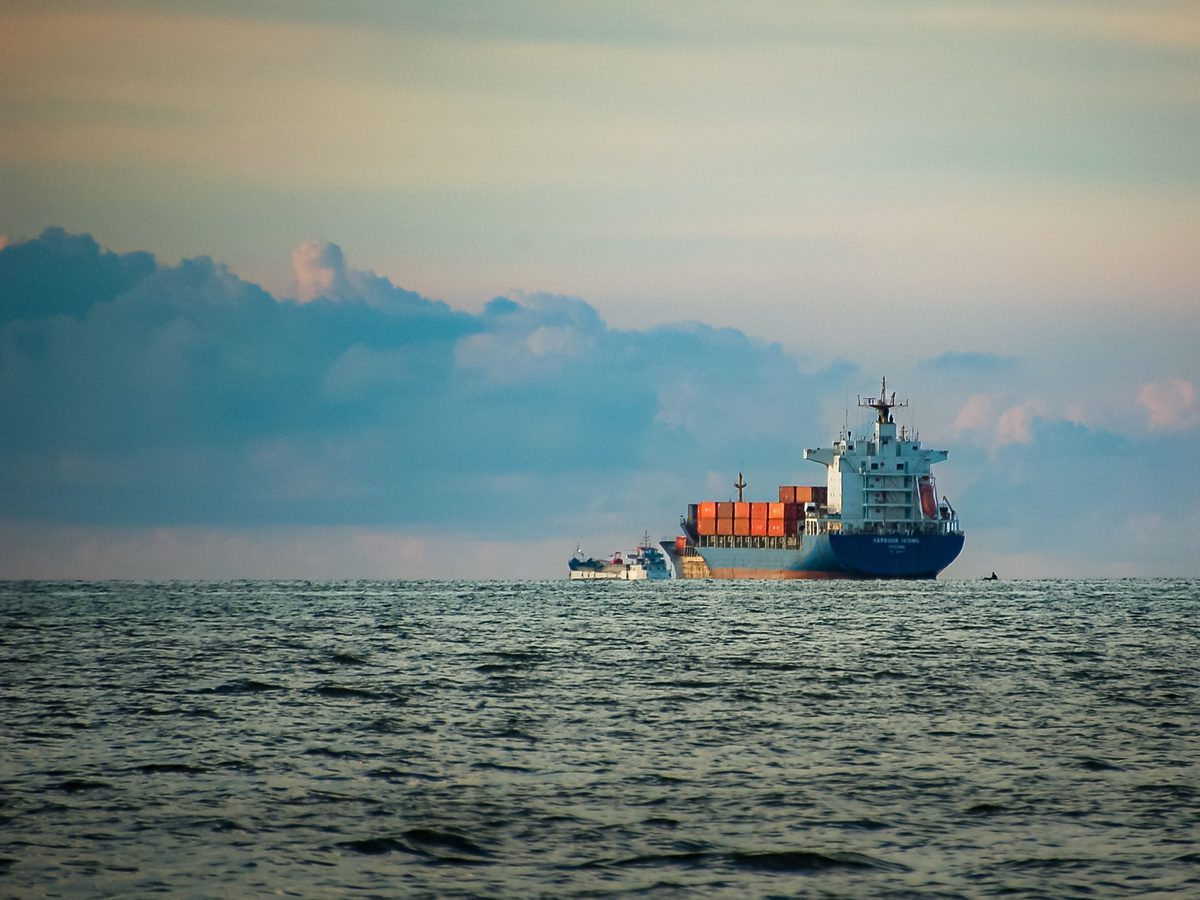 Container ship on the open sea at dusk, photographed by Hatta Sun